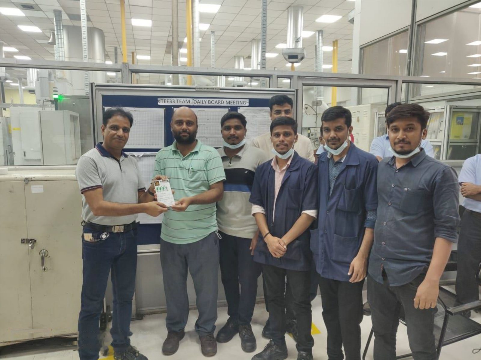 Yoganand team receiving recognition from a client at the plant